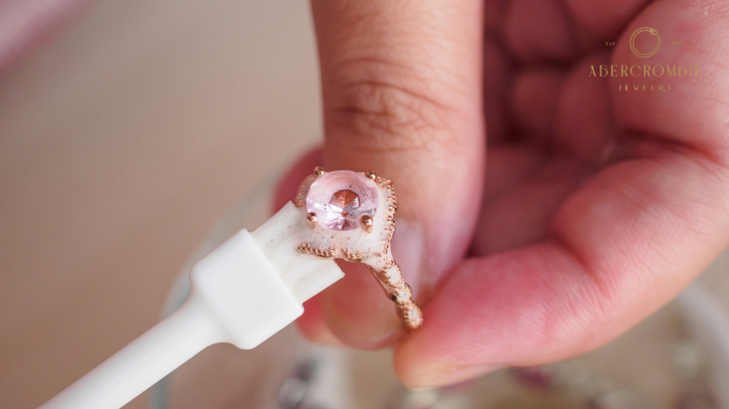person cleaning diamond studded ring