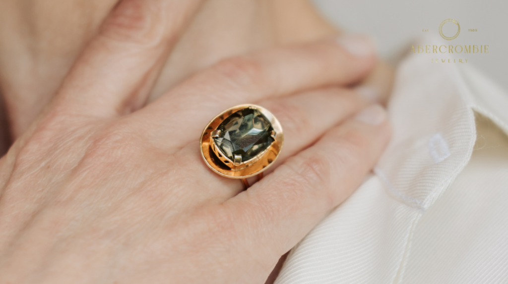 person wearing black gemstone stud gold-plated ring