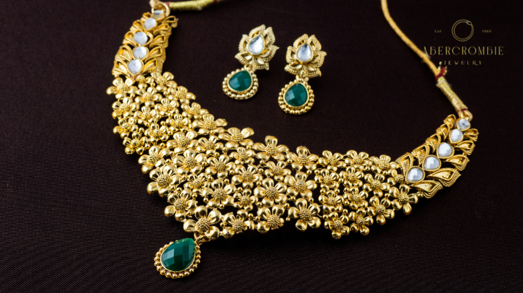 gold necklace and earrings with green gemstones